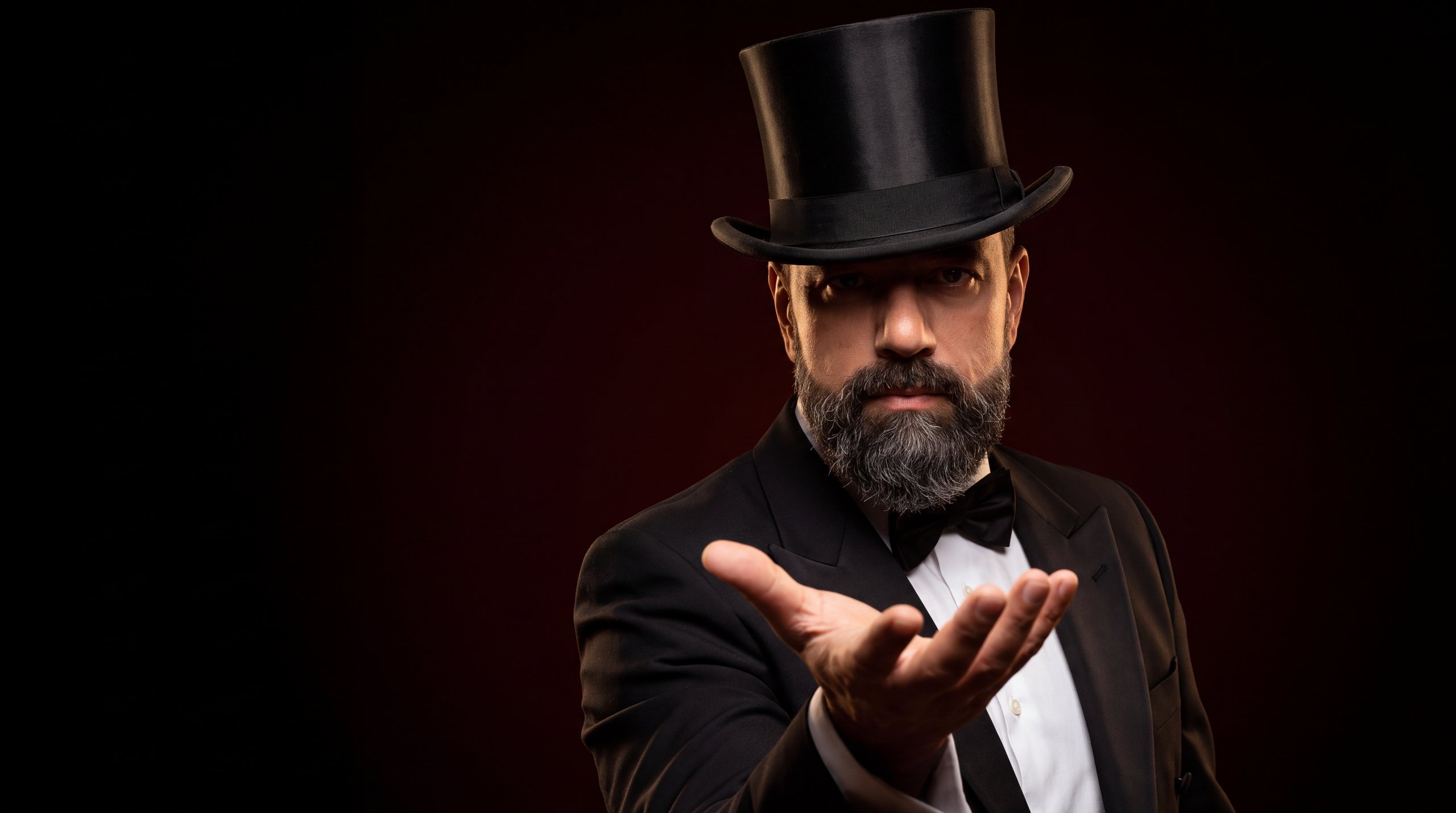 Ruben in a top hat, open palm toward the camera